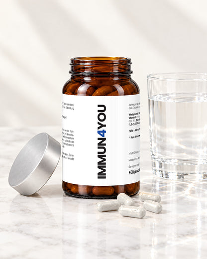 Geöffnetes IMMUN4YOU Glas mit Kapseln auf Marmor